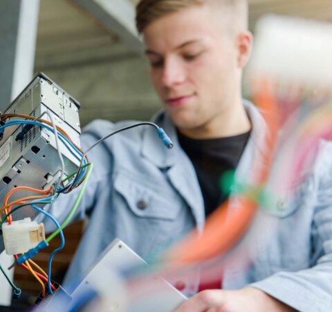 Ein Junger Mann der kleine Elektrogeräte in einer großen Tonne entsorgt. | © Die Bremer Stadtreinigung
