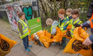 Kita Kinder bringen den gesammelten Müll zum Sammelplatz